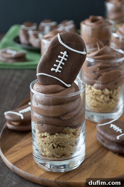 Close-up of a chocolate cheesecake football dessert shooter with peanut butter stuffed chocolate football on top.
