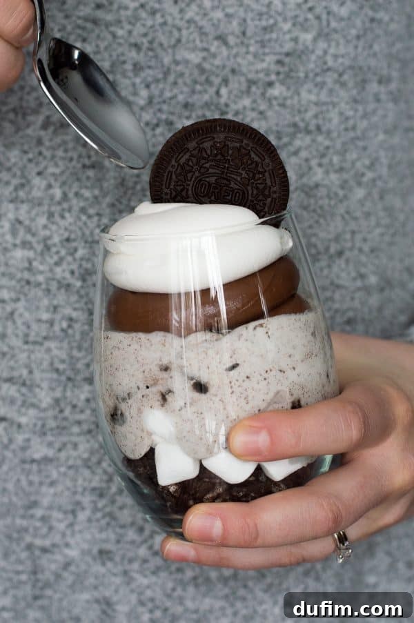 Over the Top Chocolate Cheesecake Oreo Parfaits with a whole Oreo cookie as garnish on top of the whipped cream
