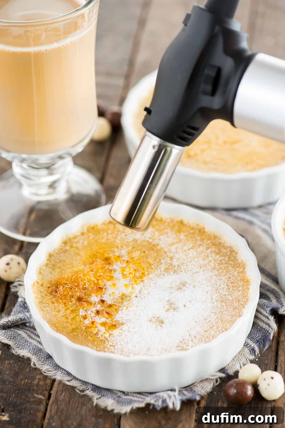 A close-up shot of a kitchen torch in action, expertly caramelizing the sugar topping on an espresso crème brûlée, creating a beautiful golden-brown crust.