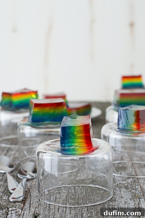A side view of the Rainbow Jello, showcasing the perfectly set and colorful layers within a clear glass pan.