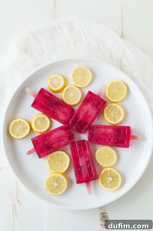 Passion Tea Lemonade Popsicles - everyone’s favorite Starbucks drink made into popsicles! A close-up of several popsicles, some with lemon slices.