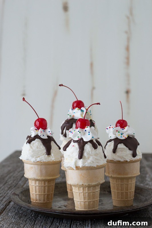 Delicious Ice Cream Cone Cupcakes topped with whipped cream, chocolate syrup, and a cherry.