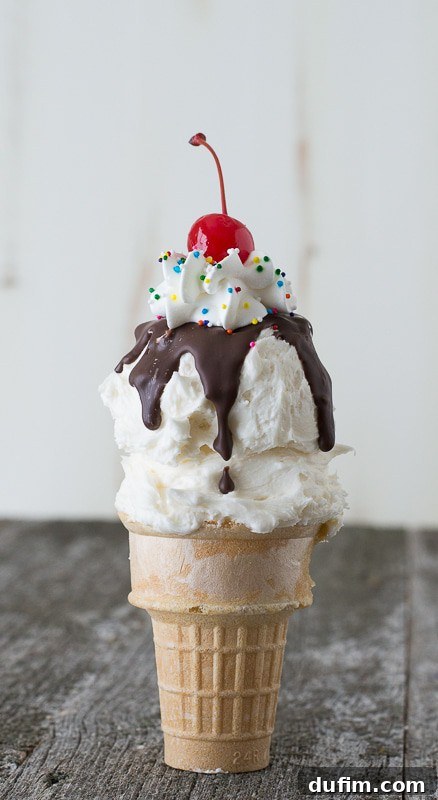 A close-up of a single Ice Cream Cone Cupcake with a cherry on top.