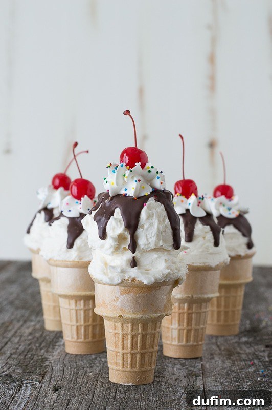 Five brightly decorated Ice Cream Cone Cupcakes on a white platter.