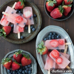 Berry Lemonade Popsicles, bursting with fresh strawberries and blueberries.