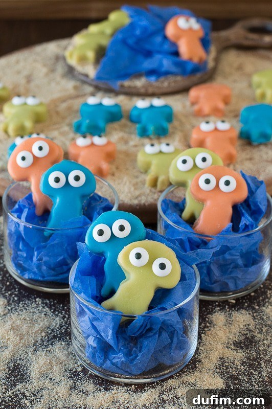 Close-up of three colorful Jellyfish Oreo Balls, decorated with candy eyes, on a light background.