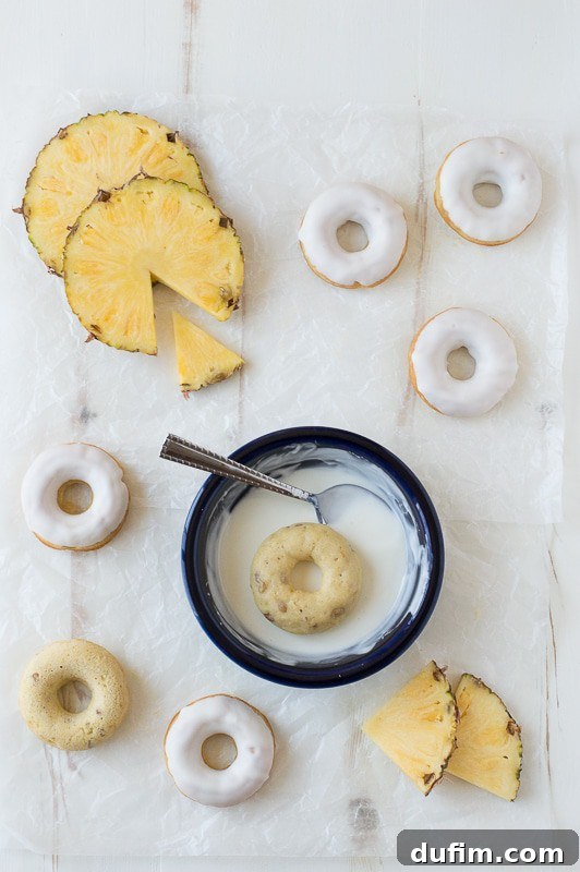 A close-up of a stack of Pineapple Walnut Donuts, showcasing their moist texture and generous glaze, ready for a tropical breakfast.
