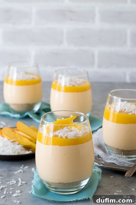 Individual Mango Coconut Cheesecake Jars, adorned with shredded coconut and fresh mango slices, ready to be enjoyed.