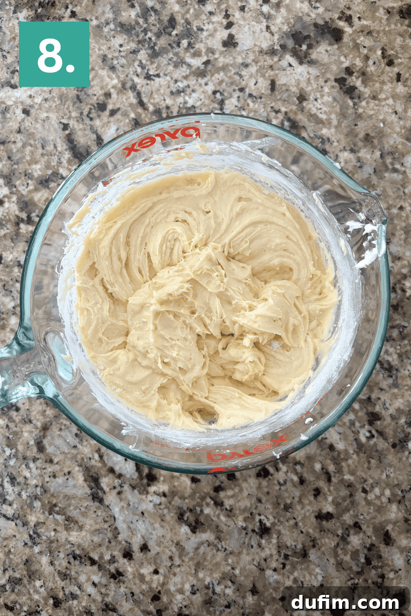 A glass measuring cup filled with a smooth, creamy, and fully mixed cake batter, ready for the next step.