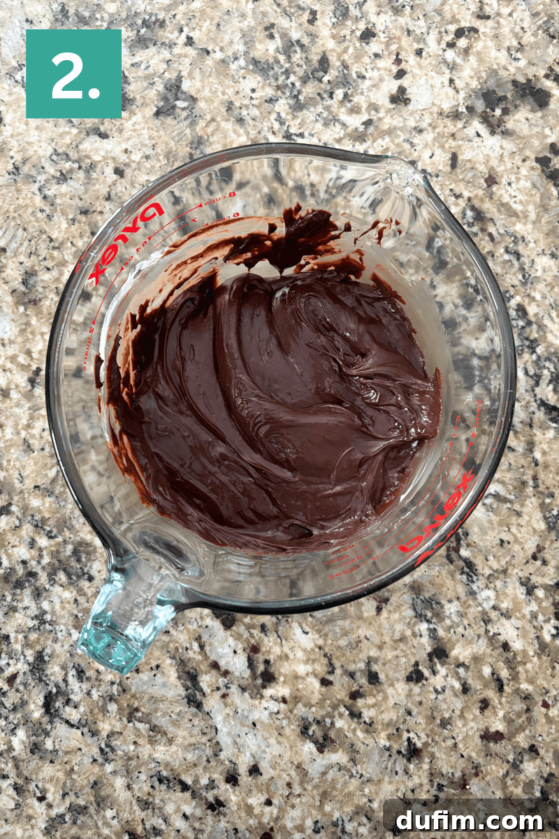 Decadent Chocolate Peanut Butter Fudge 7 A glass bowl of chocolate frosting.
