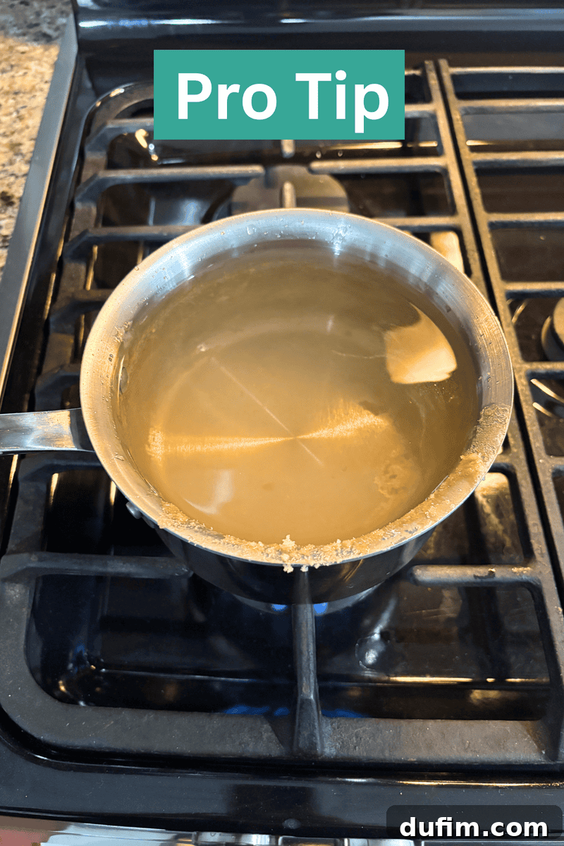 A metal pot with cloudy boiling water sits on a gas stove. Residue clings to the rim. At the top of the image, text reads Pro Tip in bold white letters on a green background.
