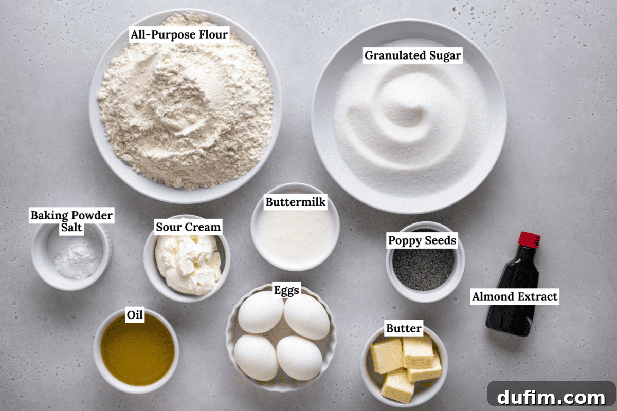 Irresistible Almond Poppy Seed Muffins 4 A top-down view of carefully labeled baking ingredients in individual bowls, including all-purpose flour, granulated sugar, baking powder, salt, sour cream, buttermilk, poppy seeds, eggs, almond extract, butter, and oil, all arranged on a pristine light surface.