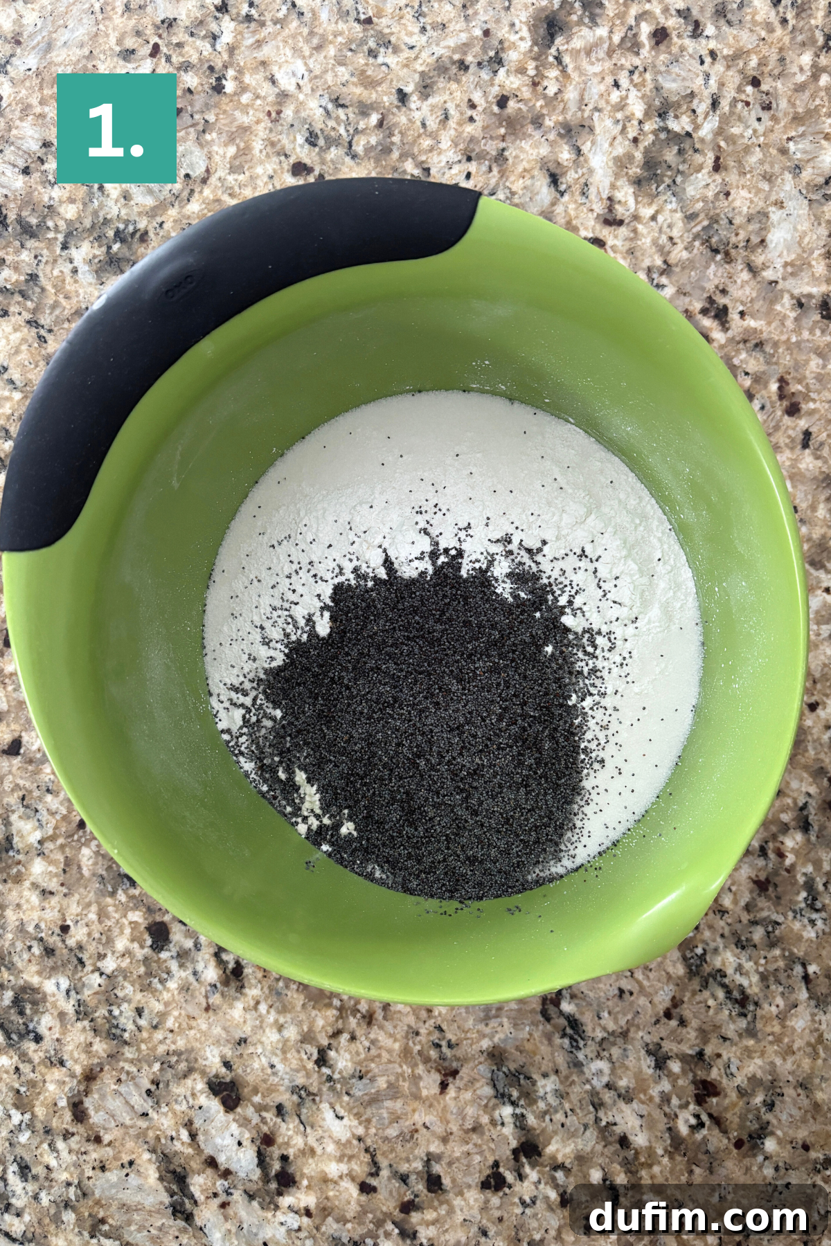 Irresistible Almond Poppy Seed Muffins 5 Dry ingredients including flour and poppy seeds are carefully combined in a vibrant green mixing bowl, set against a speckled granite countertop.