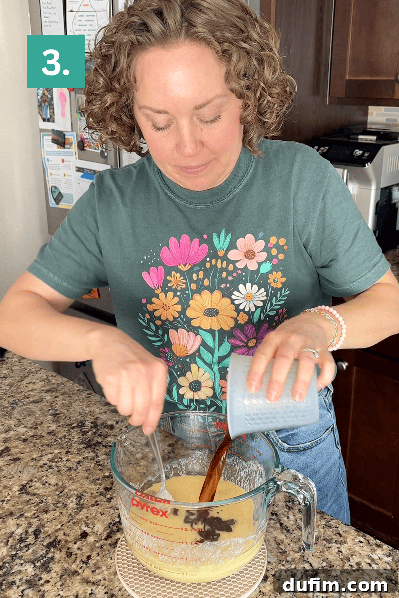Decadent Homemade 9x13 Chocolate Cake 8 Step three of mixing the batter: Pouring the combined wet ingredients into the bowl of dry ingredients.