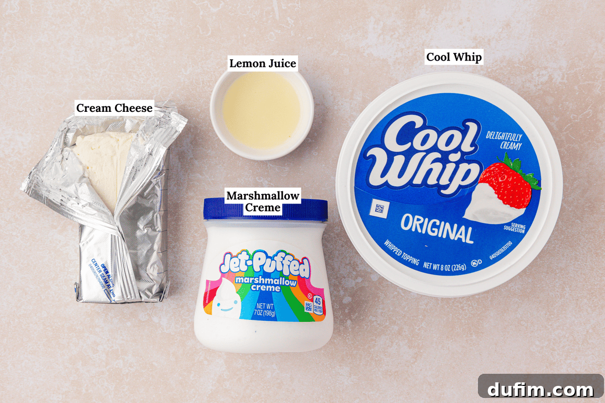 Cream Cheese Fruit Dip Recipe for Parties and Snacks 4 Four ingredients on a countertop: an unwrapped block of cream cheese, a small bowl of lemon juice, a jar of marshmallow creme, and a large tub of Cool Whip. Each item is labeled.