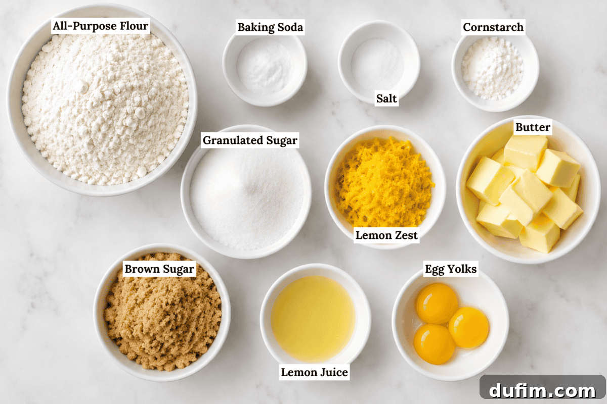Top-down view of labeled baking ingredients in bowls: flour, baking soda, cornstarch, salt, granulated sugar, brown sugar, lemon zest, lemon juice, butter cubes, and three egg yolks.