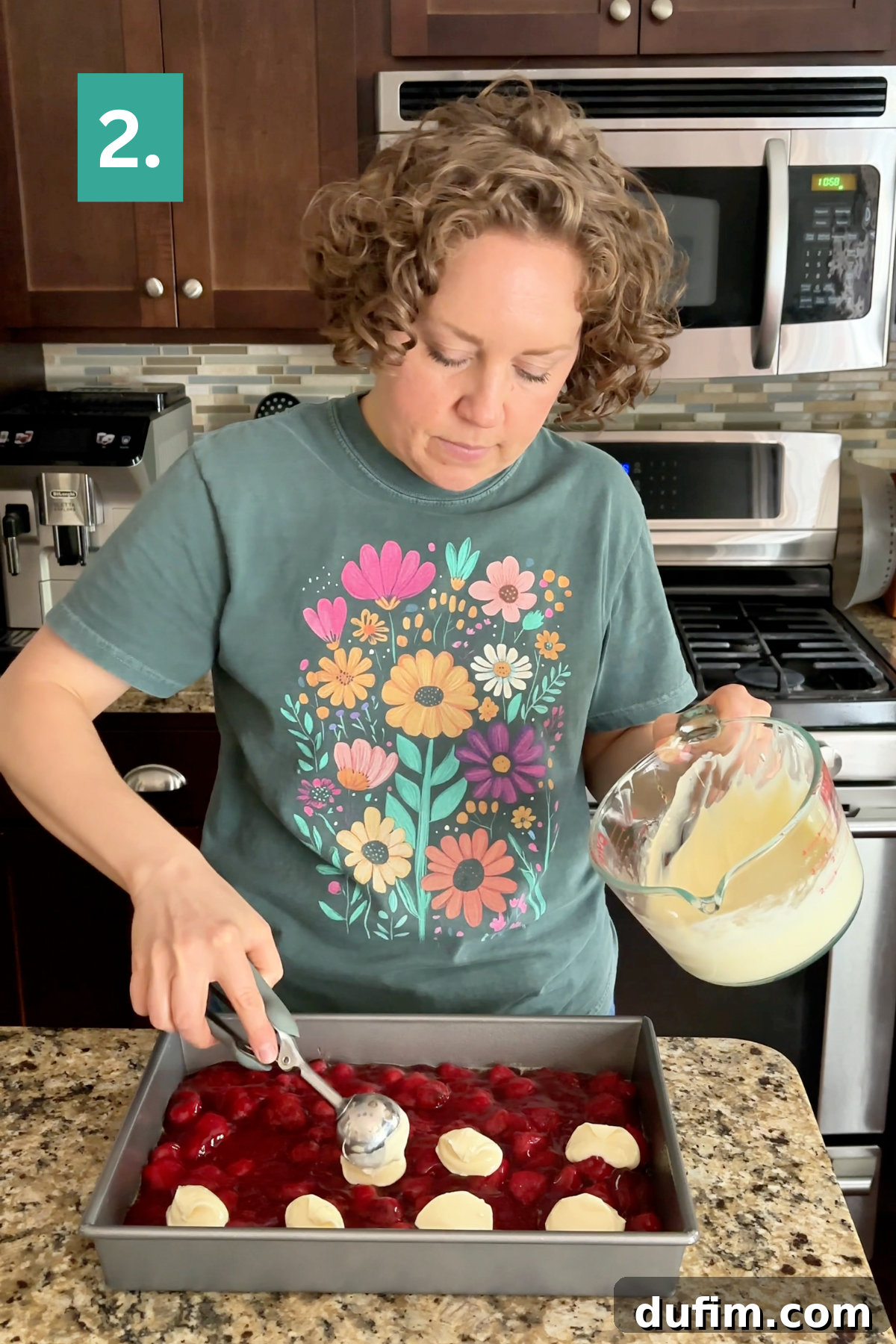 A person scoops batter onto a Strawberry Cheesecake Dump Cake in a pan.