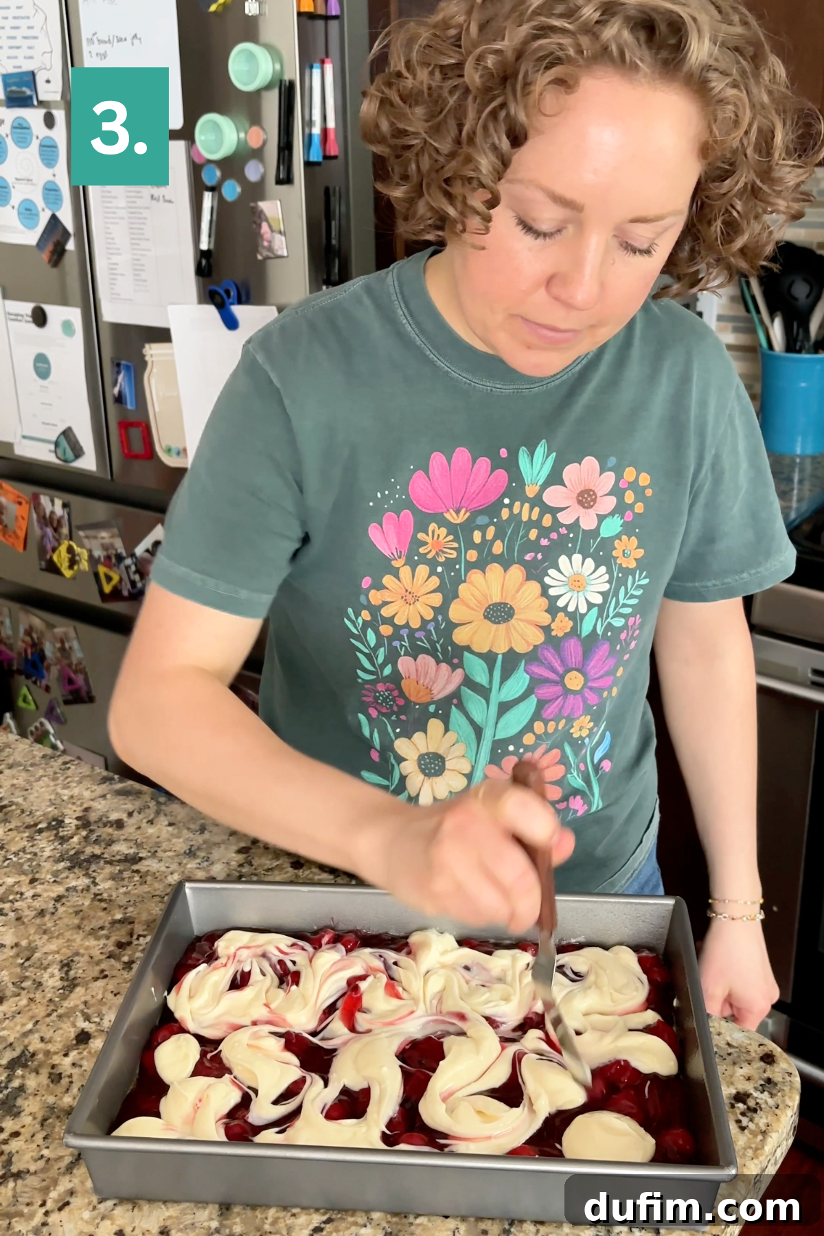 A person swirls cream cheese into a vibrant red batter for the dessert.