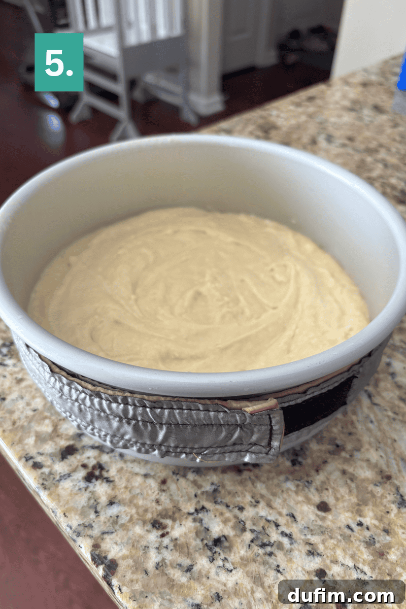 Homemade Coconut Cake That Tastes Like Real Coconut 7 A round cake pan with light batter inside sits on a granite countertop.
