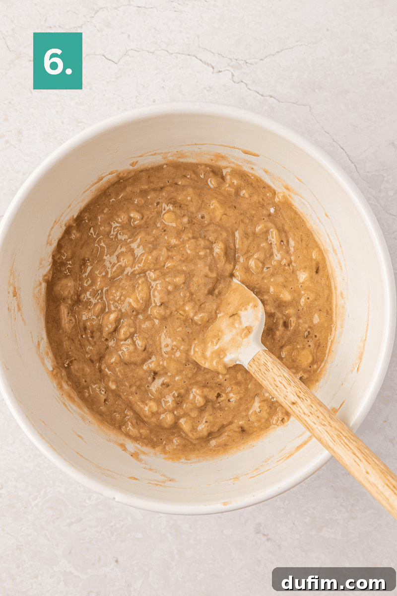 Moist Gluten-Free Banana Bread Recipe 11 A white bowl with banana bread batter and a spatula inside.