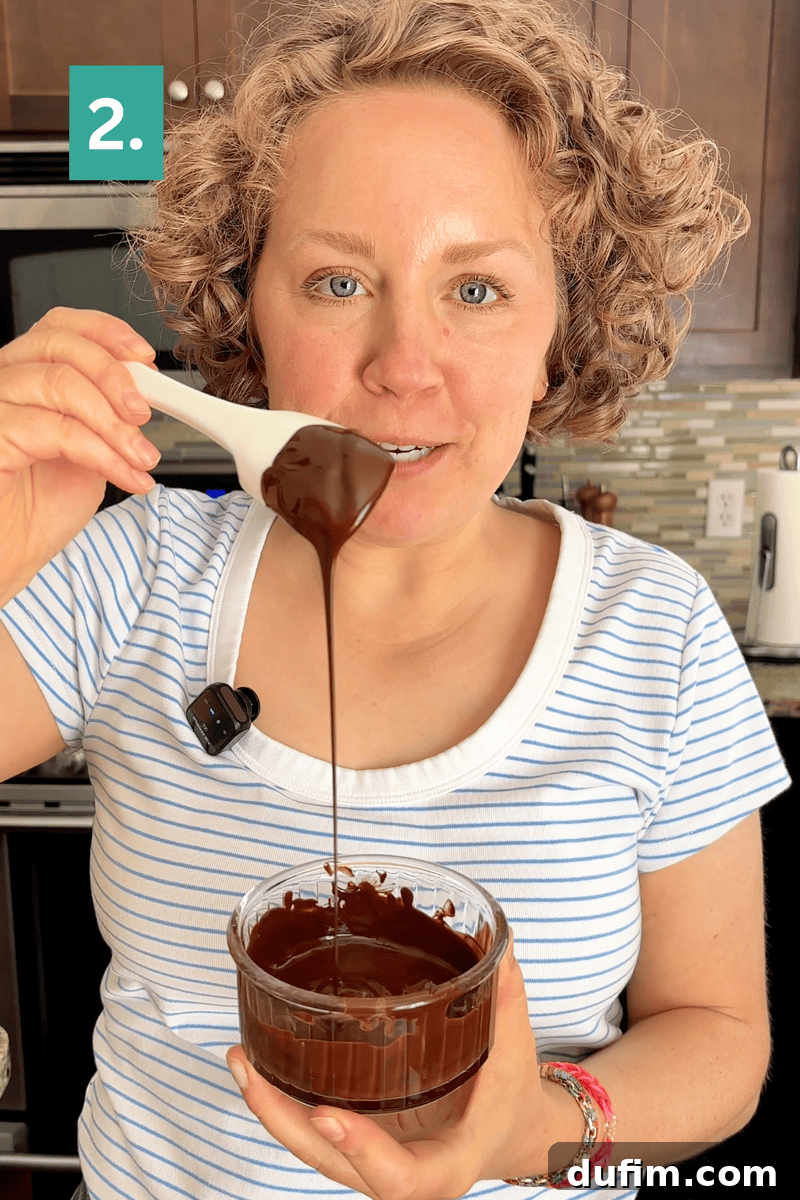 Decadent Mocha Cake Recipe for Coffee Lovers 8 A woman in a striped shirt holds a glass bowl of melted chocolate and lifts some with a spoon. There is a 2. label in the top left corner.